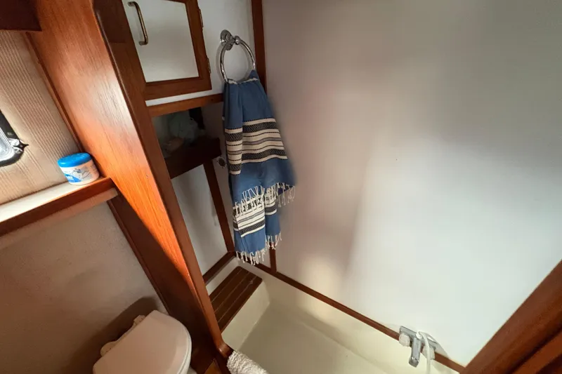 Slide: The Image of 1988 Carver 36 Aft Cabin bathroom with wooden accents and blue towel. - 61