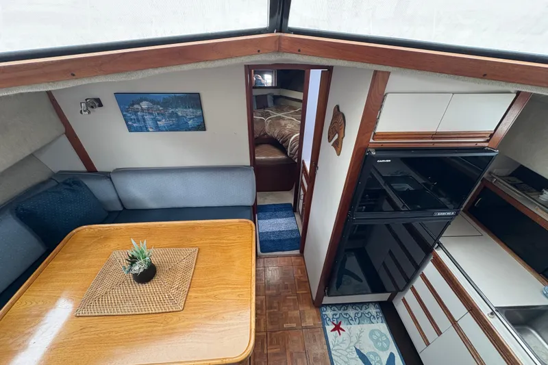 Slide: The Image of 1988 Carver 36 Aft Cabin interior with dining area, kitchenette, and cozy bedroom. - 63