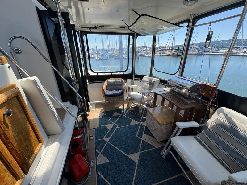 Slide: The Image of 1988 Carver 36 Aft Cabin interior with seating, table, and marina view. - 8