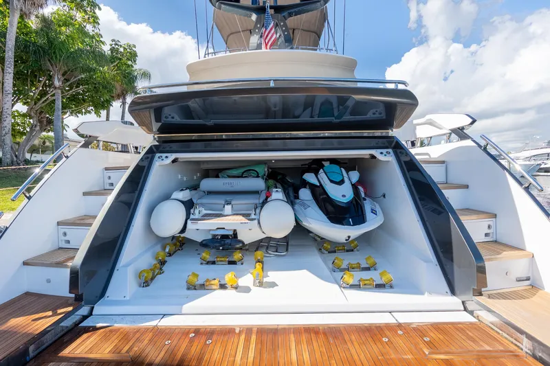Slide: The Image of 2023 Azimut S8 yacht with open garage, featuring watercraft and equipment. - 12