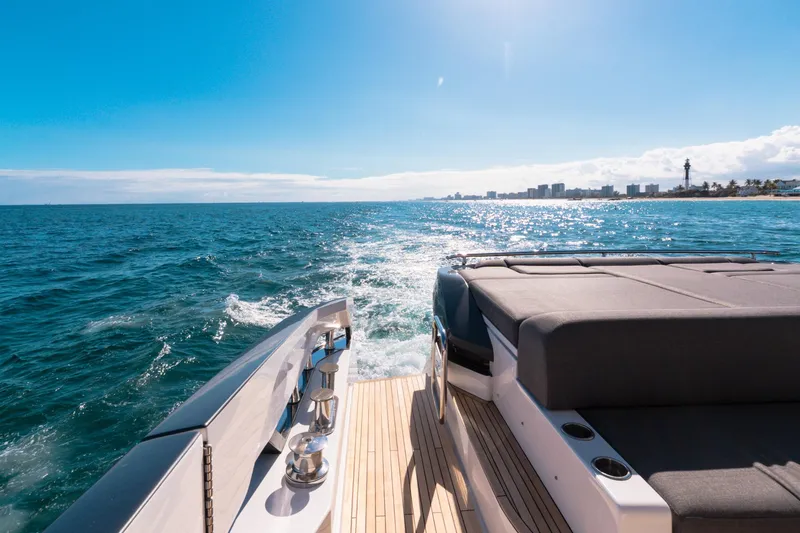 Slide: The Image of 2023 Azimut S8 yacht cruising on a sunny ocean, with city skyline in the background. - 20