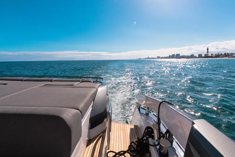Slide: The Image of 2023 Azimut S8 yacht cruising on sunny ocean with city skyline in background. - 21
