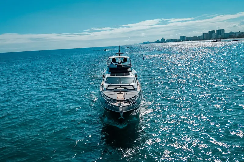 Slide: The Image of 2023 Azimut S8 yacht cruising on sparkling blue ocean near city skyline. - 4