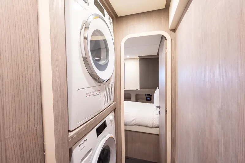 Slide: The Image of 2023 Azimut S8 yacht interior with laundry appliances and cozy bedroom. - 89