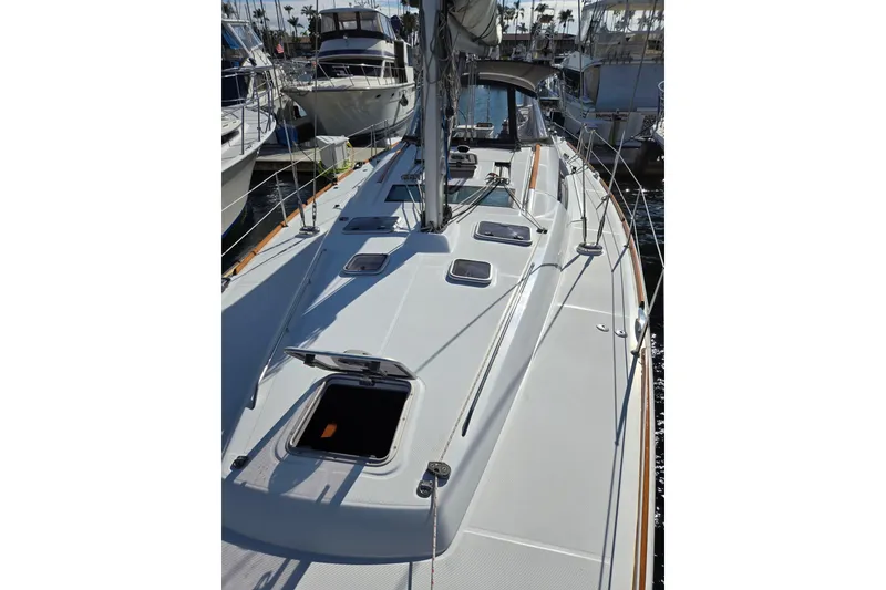 Slide: The Image of 2008 Beneteau Oceanis 49 sailboat deck view in marina, showcasing sleek design and open hatches. - 11
