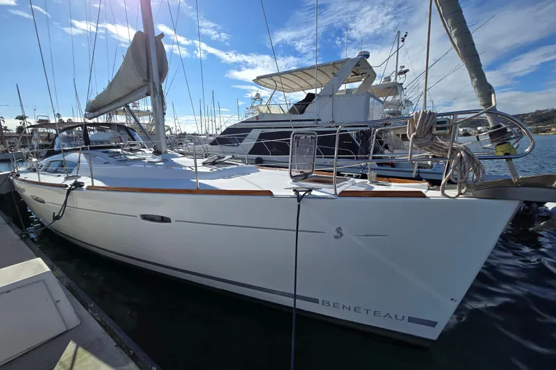 Slide: The Image of 2008 Beneteau Oceanis 49 sailboat docked in a marina under a clear blue sky. - 13