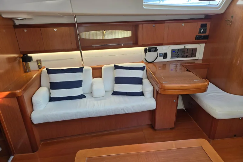 Slide: The Image of Interior of 2008 Beneteau Oceanis 49 yacht with cozy seating and striped cushions. - 24