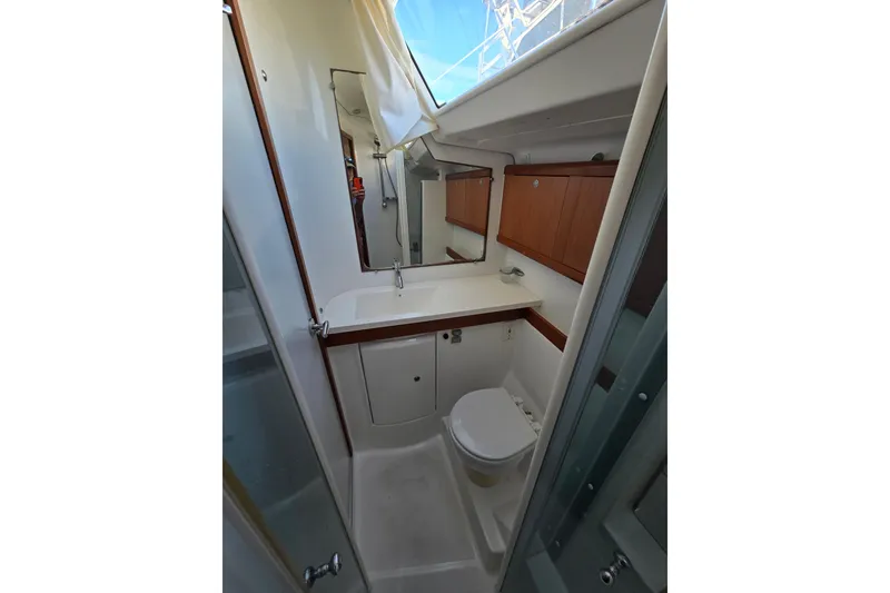 Slide: The Image of 2008 Beneteau Oceanis 49 yacht bathroom with modern fixtures and wooden cabinetry. - 35