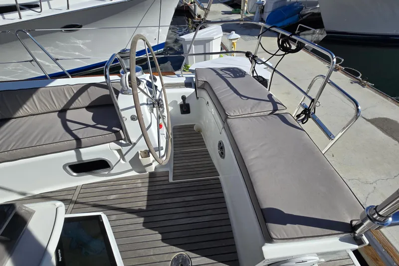 Slide: The Image of Cockpit of 2008 Beneteau Oceanis 49 sailboat with cushioned seating and steering wheel. - 9