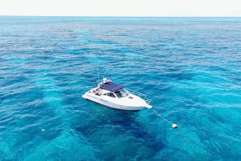 Slide: The Image of 2003 Tiara Yachts 2900 Coronet anchored in clear blue ocean waters. - 2
