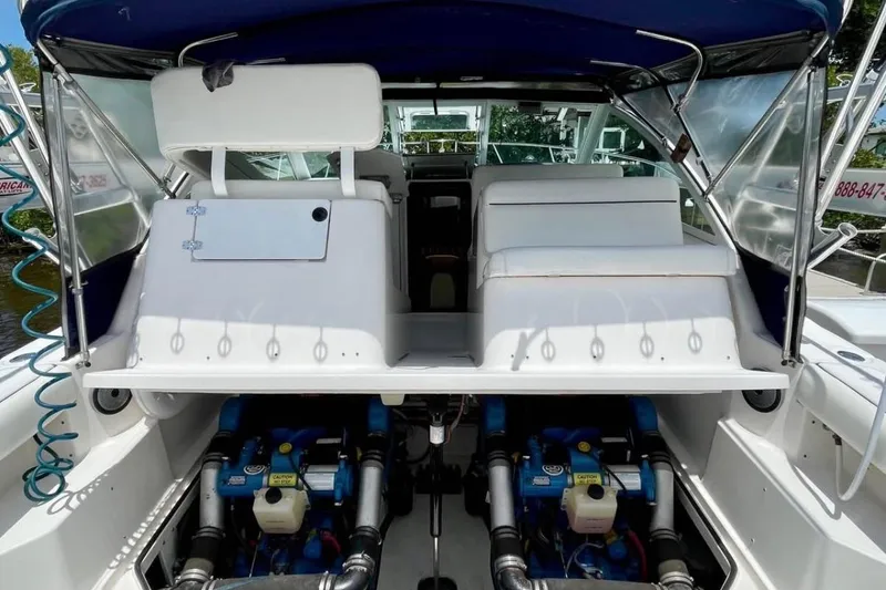 Slide: The Image of 2003 Tiara Yachts 2900 Coronet interior with engine view, featuring white seating and canopy. - 8