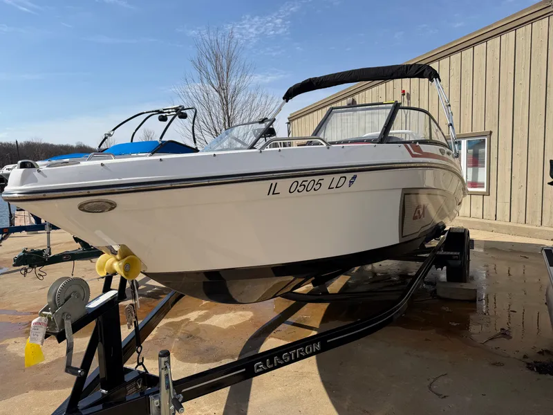 Slide: The Image of 2022 Glastron 210 GX boat on trailer outside building. - 1
