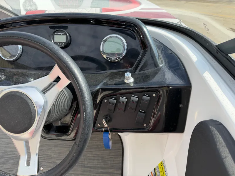 Slide: The Image of Dashboard of a 2022 Glastron 210 GX boat with steering wheel and instruments. - 13