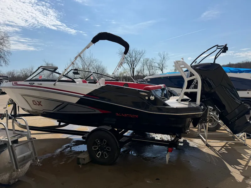 Slide: The Image of 2022 Glastron 210 GX boat on trailer outdoors. - 2