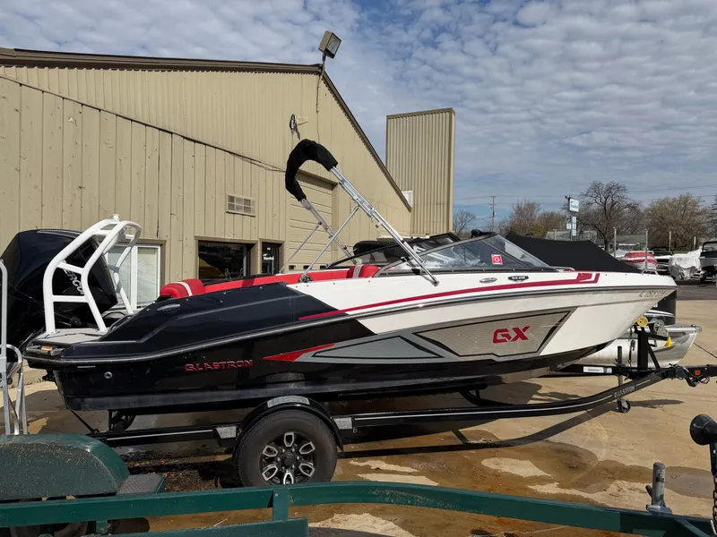 Slide: The Image of 2022 Glastron 210 GX boat on trailer outside warehouse. - 4