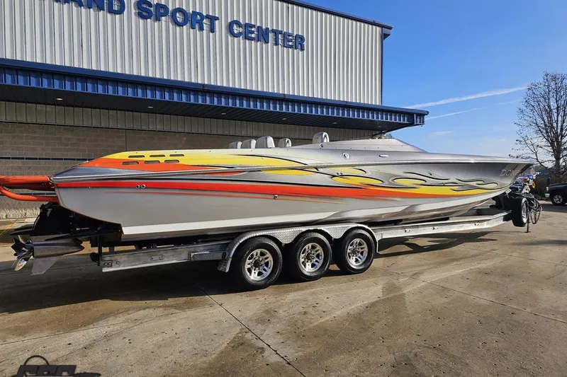 Slide: The Image of 2007 Donzi 38 ZR speedboat with vibrant flame graphics on a trailer outside a sports center. - 10