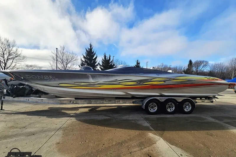 Slide: The Image of 2007 Donzi 38 ZR speedboat with vibrant graphics on a trailer, parked outdoors. - 19