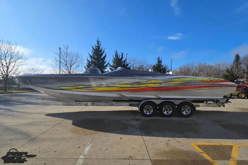 Slide: The Image of 2007 Donzi 38 ZR speedboat with vibrant graphics on a trailer, parked outdoors. - 20