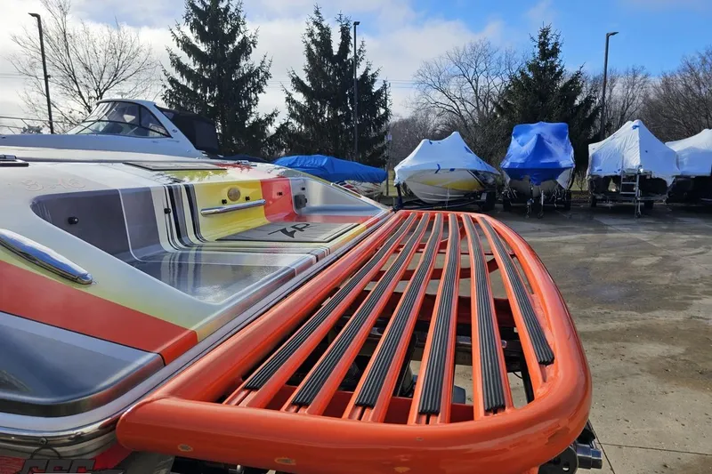 Slide: The Image of 2007 Donzi 38 ZR boat with vibrant design, parked outdoors with covered boats nearby. - 28