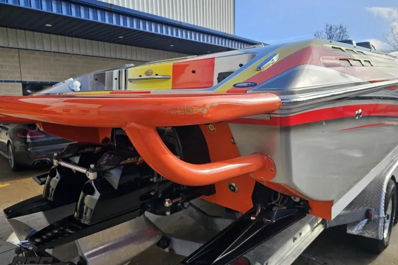 Slide: The Image of 2007 Donzi 38 ZR speedboat with vibrant orange and red detailing, docked outdoors. - 34