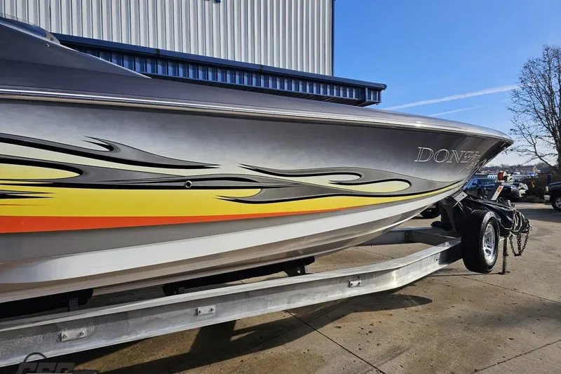 Slide: The Image of 2007 Donzi 38 ZR speedboat with vibrant flame graphics on a trailer. - 6