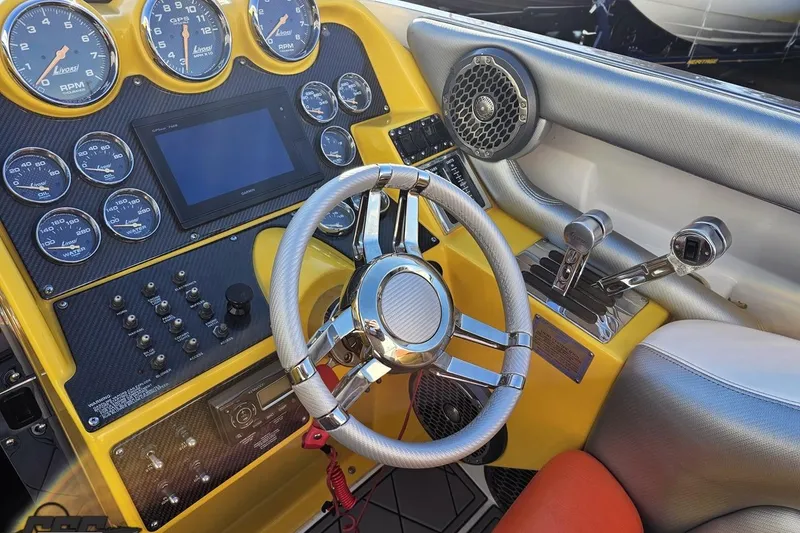 Slide: The Image of 2007 Donzi 38 ZR boat cockpit with yellow dashboard, gauges, and chrome steering wheel. - 81