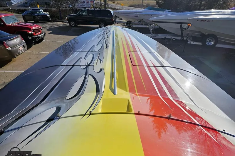 Slide: The Image of 2007 Donzi 38 ZR boat with vibrant, colorful graphics on deck, parked outdoors. - 91