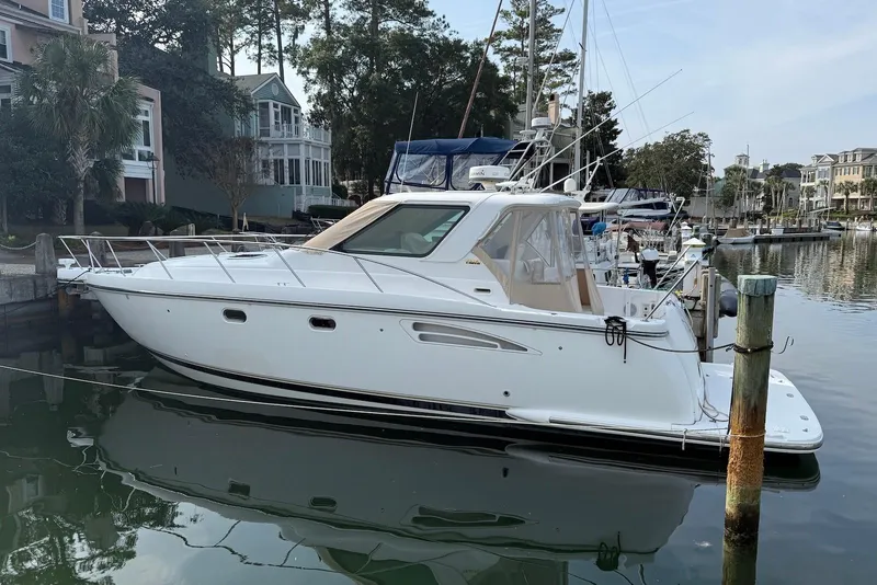 Slide: The Image of 2004 Tiara Yachts 3600 Sovran docked in a serene marina setting. - 1