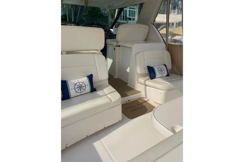 Slide: The Image of 2004 Tiara Yachts 3600 Sovran interior with white seating and nautical-themed pillows. - 12
