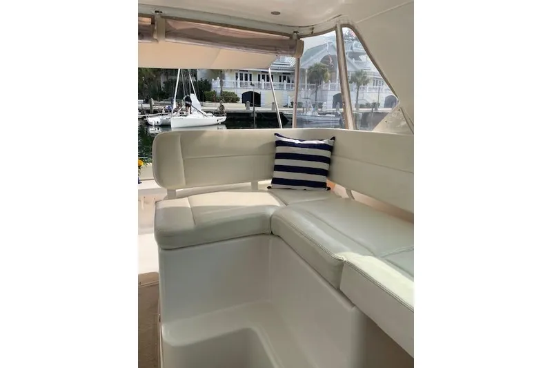 Slide: The Image of 2004 Tiara Yachts 3600 Sovran interior with white seating and striped cushion. - 13