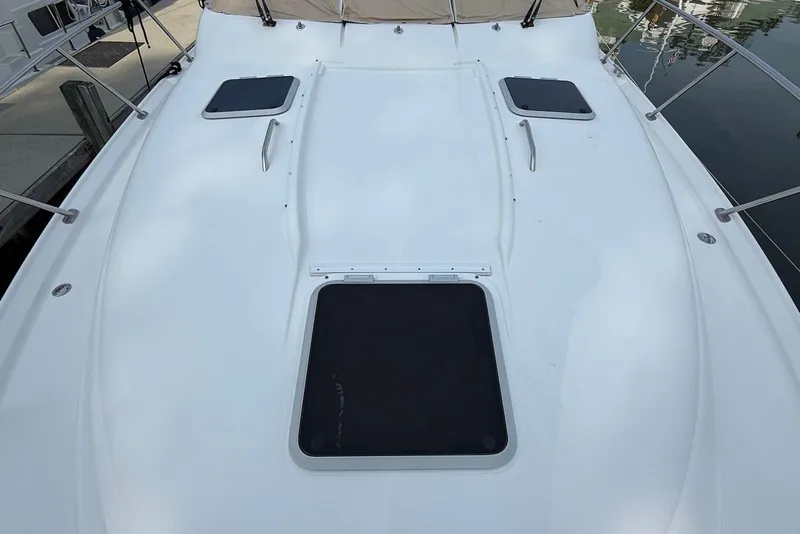 Slide: The Image of 2004 Tiara Yachts 3600 Sovran deck with hatches and railings, docked at marina. - 22