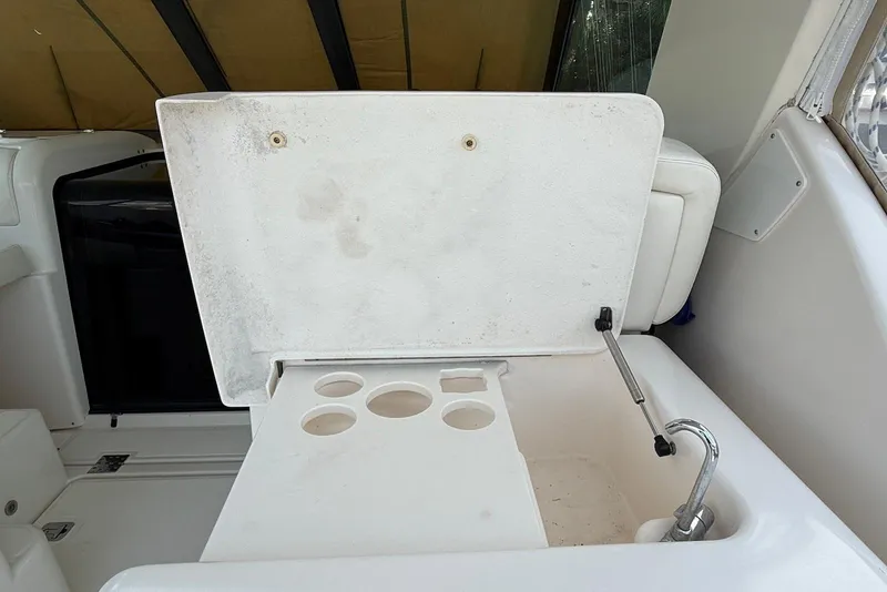 Slide: The Image of 2004 Tiara Yachts 3600 Sovran cockpit sink with cup holders and storage. - 23