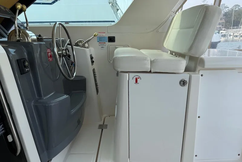 Slide: The Image of 2004 Tiara Yachts 3600 Sovran helm with steering wheel and cushioned seating. - 26