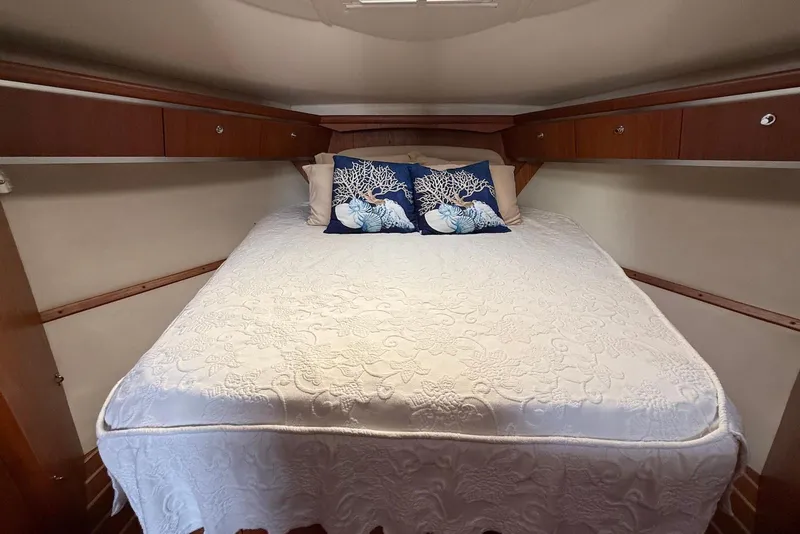 Slide: The Image of Cozy cabin bedroom in 2004 Tiara Yachts 3600 Sovran with elegant bedding and wooden storage. - 36
