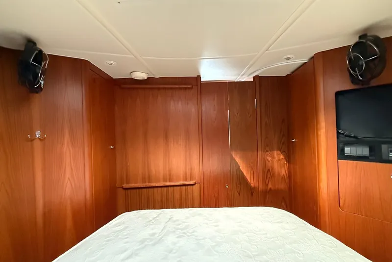 Slide: The Image of 2004 Tiara Yachts 3600 Sovran cabin interior with wood paneling and bed. - 40