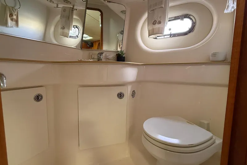 Slide: The Image of 2004 Tiara Yachts 3600 Sovran bathroom with porthole, mirror, and toilet. - 42