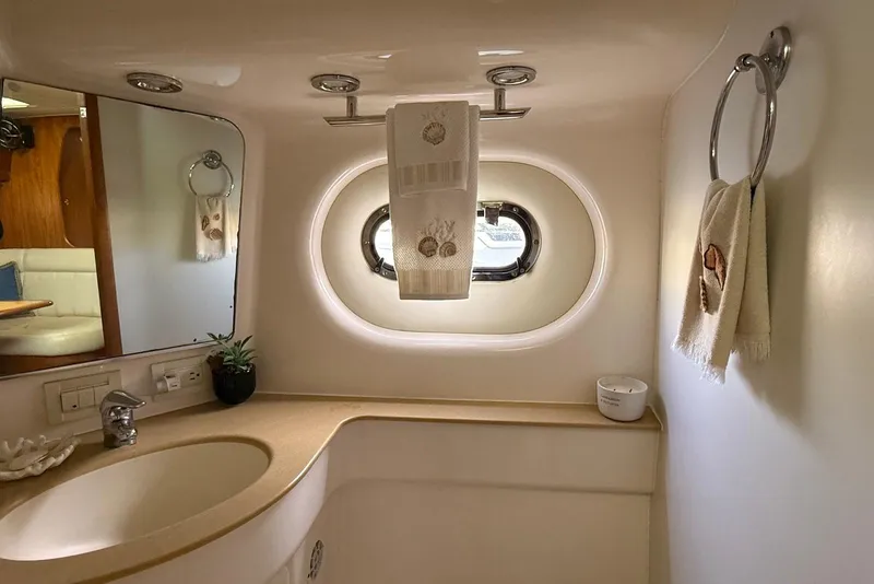 Slide: The Image of Luxurious bathroom in 2004 Tiara Yachts 3600 Sovran with elegant fixtures and porthole window. - 44