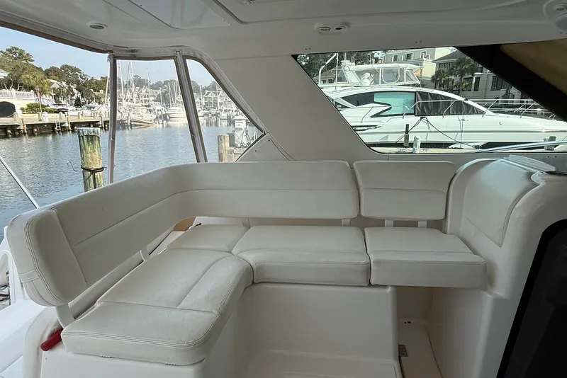 Slide: The Image of 2004 Tiara Yachts 3600 Sovran interior with white seating, docked at marina. - 9
