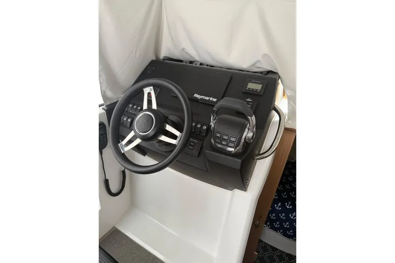 Slide: The Image of 2019 Jeanneau NC 9 helm with Raymarine controls and steering wheel. - 13