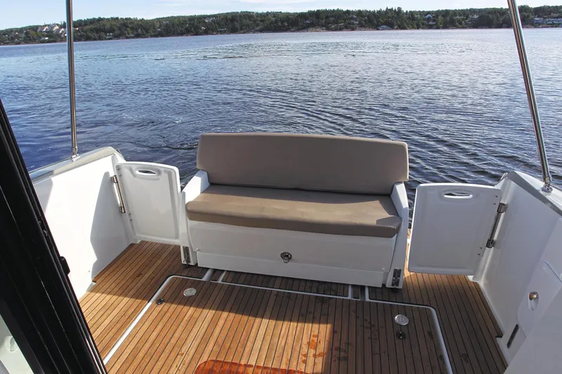 Slide: The Image of Manufacturer Provided Image: 2018 Jeanneau NC 9 boat with rear deck seating and scenic water view. - 16