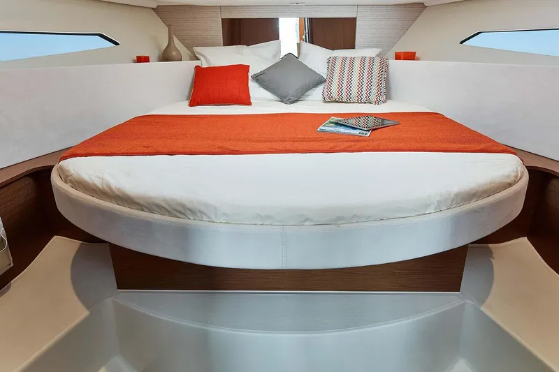 Slide: The Image of Manufacturer Provided Image: 2018 Jeanneau NC 9 boat interior with cozy bed and vibrant orange accents. - 20