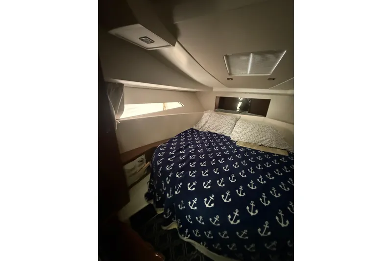 Slide: The Image of Cozy cabin interior of 2019 Jeanneau NC 9 with anchor-patterned bedding. - 4