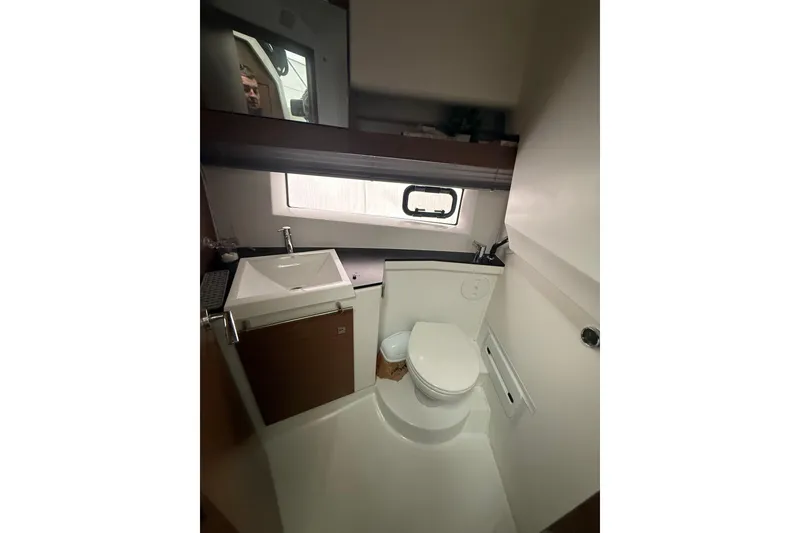 Slide: The Image of 2019 Jeanneau NC 9 boat bathroom with sink, toilet, and window. - 5