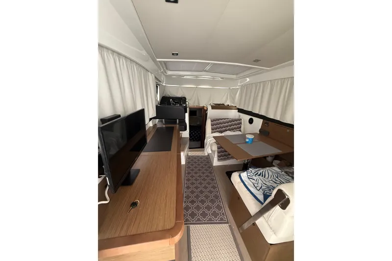 Slide: The Image of Interior of 2019 Jeanneau NC 9 boat with modern furnishings and cozy seating area. - 9