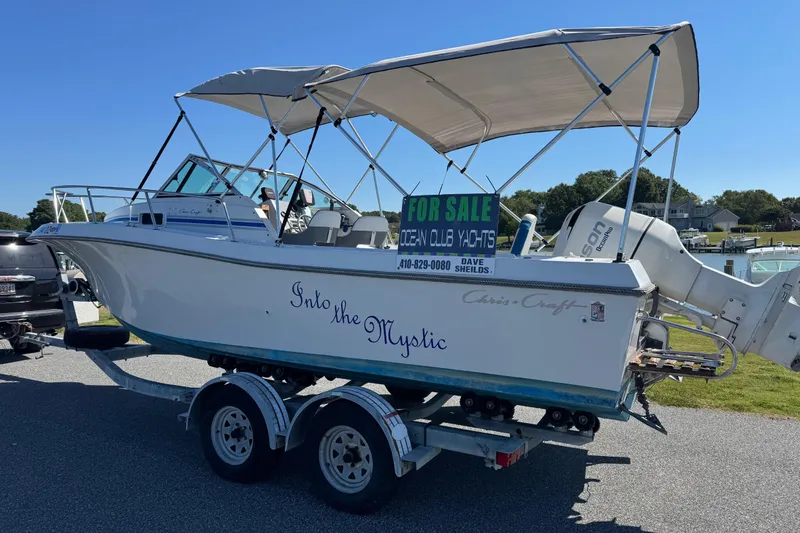 Slide: The Image of 1988 Chris-Craft 215 Sea Hawk boat for sale on trailer, featuring canopy and outboard motor. - 17