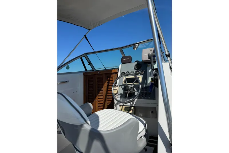 Slide: The Image of 1988 Chris-Craft 215 Sea Hawk boat cockpit with steering wheel and navigation equipment. - 21