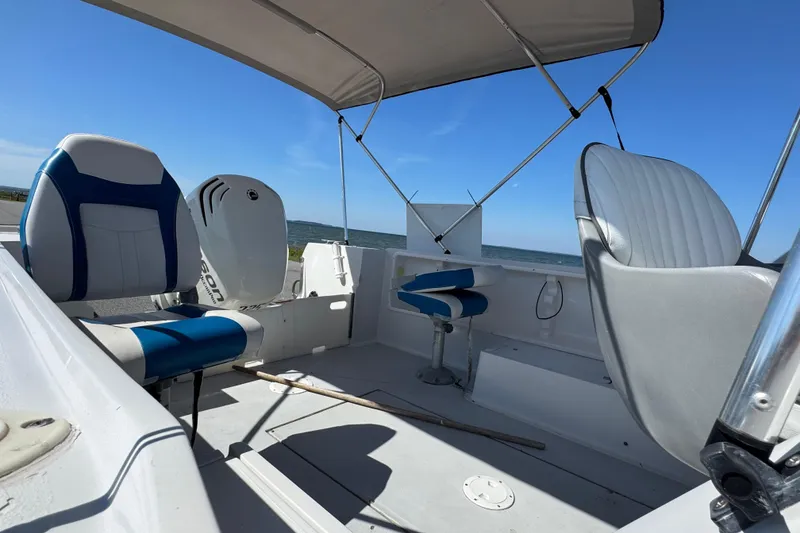 Slide: The Image of 1988 Chris-Craft 215 Sea Hawk boat interior with seating and canopy, ocean view. - 23