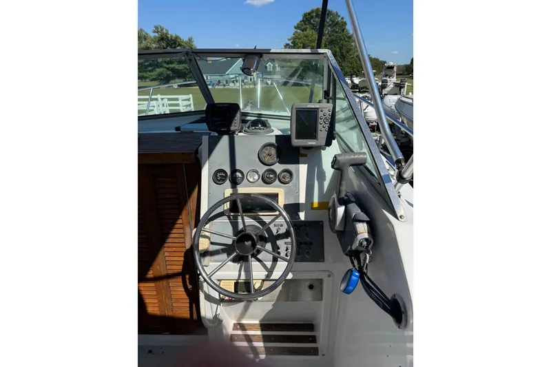 Slide: The Image of 1988 Chris-Craft 215 Sea Hawk boat dashboard with steering wheel and navigation instruments. - 24