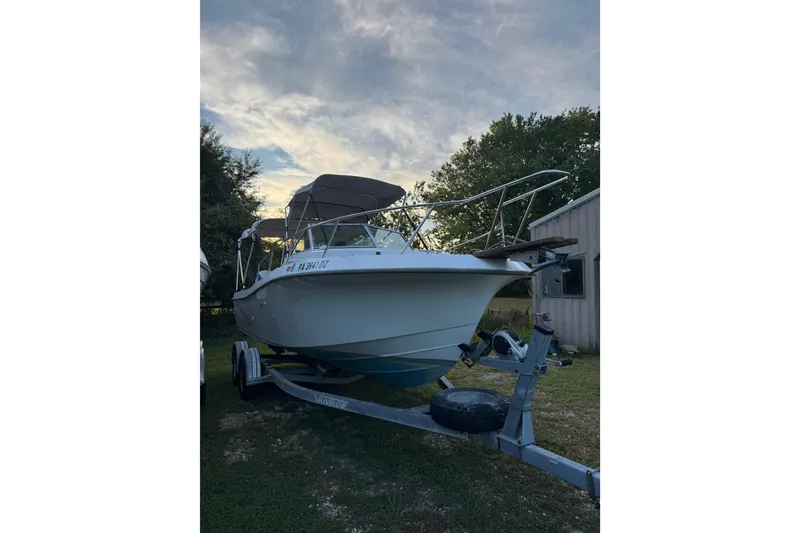 Slide: The Image of 1988 Chris-Craft 215 Sea Hawk boat on trailer, parked outdoors at sunset. - 3