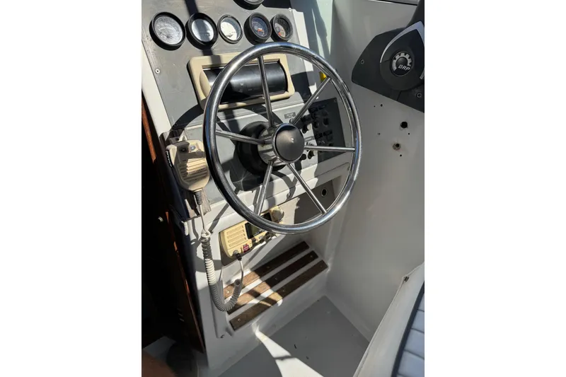 Slide: The Image of 1988 Chris-Craft 215 Sea Hawk boat dashboard with steering wheel and gauges. - 42